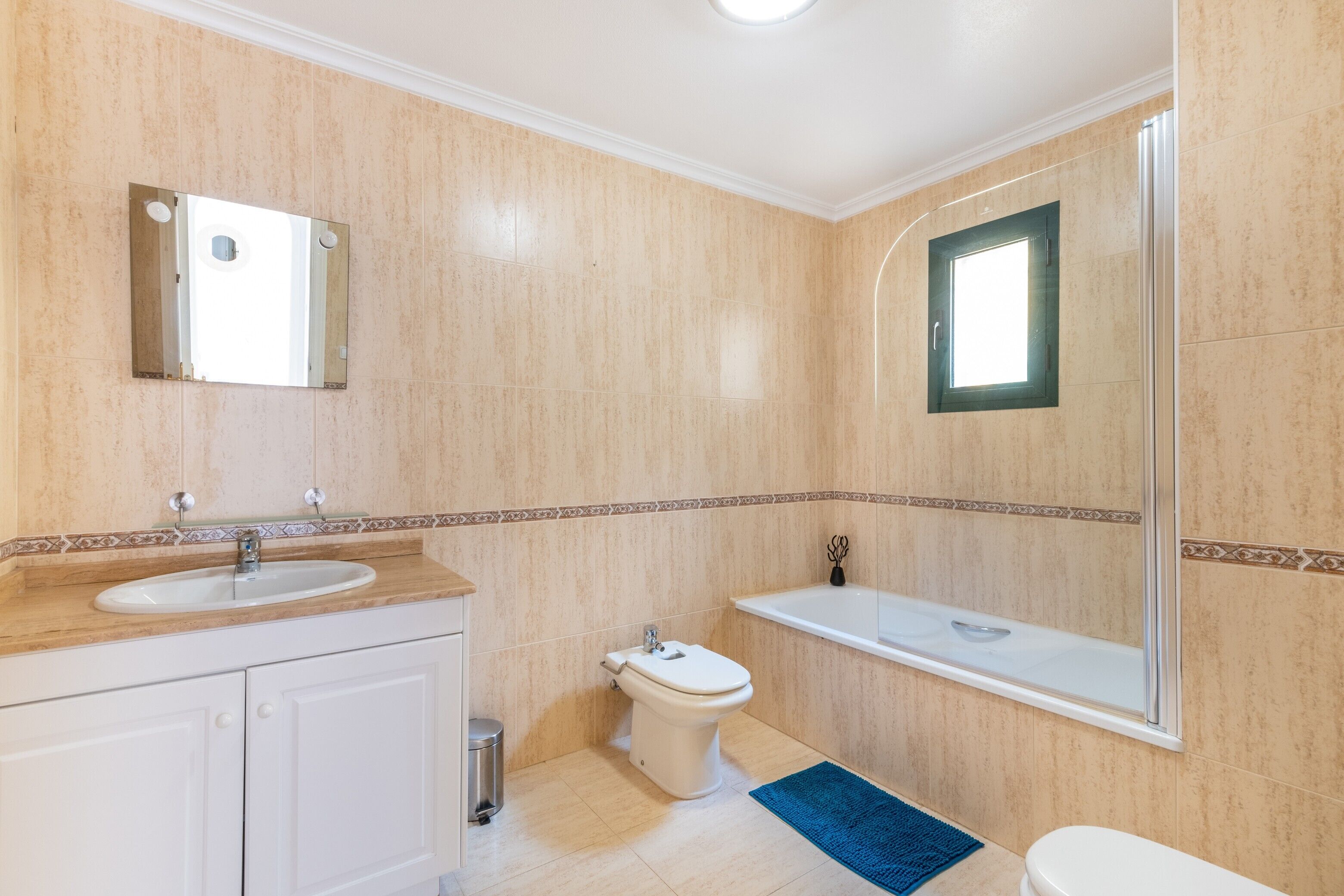 Un baño con lavamanos, inodoro y bañera.