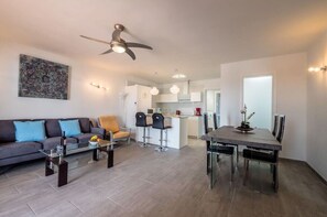 Un appartement moderne comprenant un salon, un coin repas, une cuisine et un ventilateur de plafond.