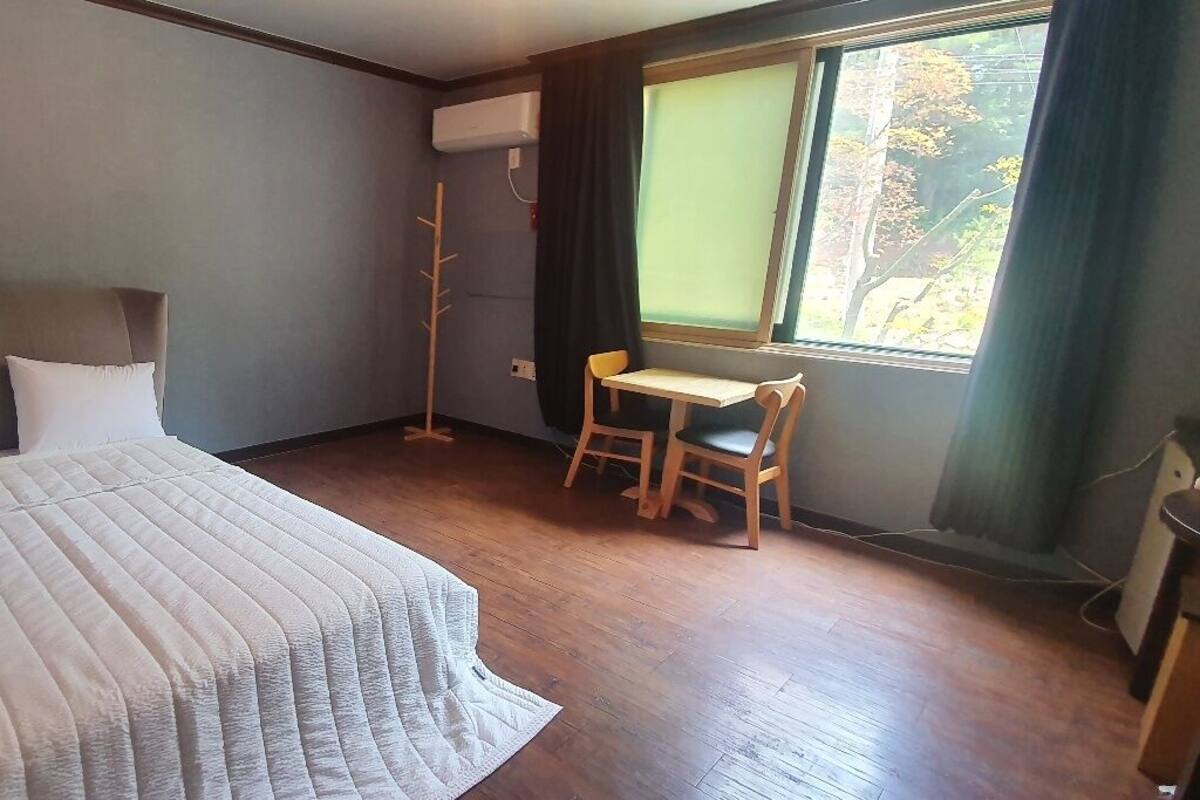Un dormitorio con cama, escritorio y silla.