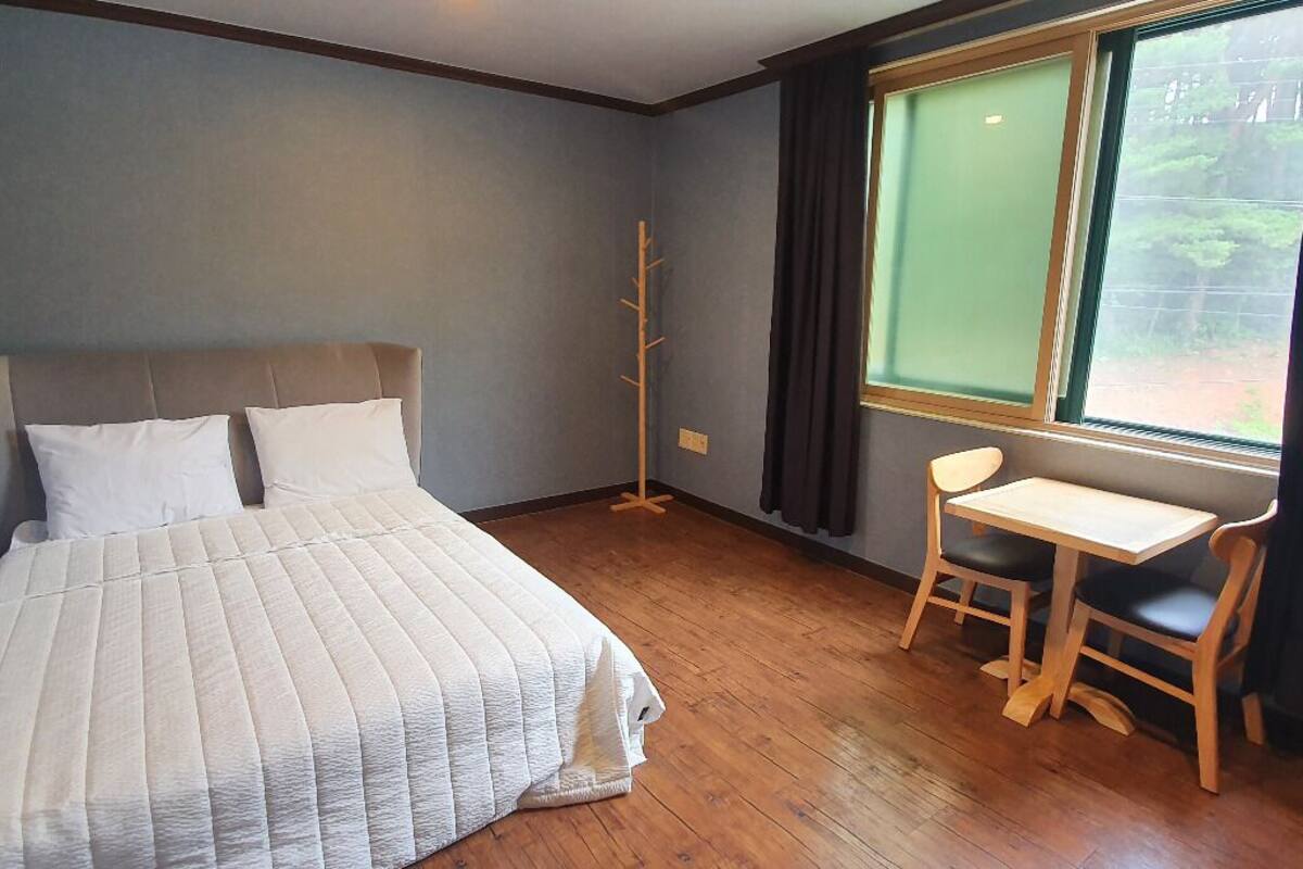 Un dormitorio con una cama, un escritorio y una silla.