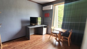 A room with a wooden desk, a chair, a television, and a window with a view of greenery. - Bigso stay (Yangyang)