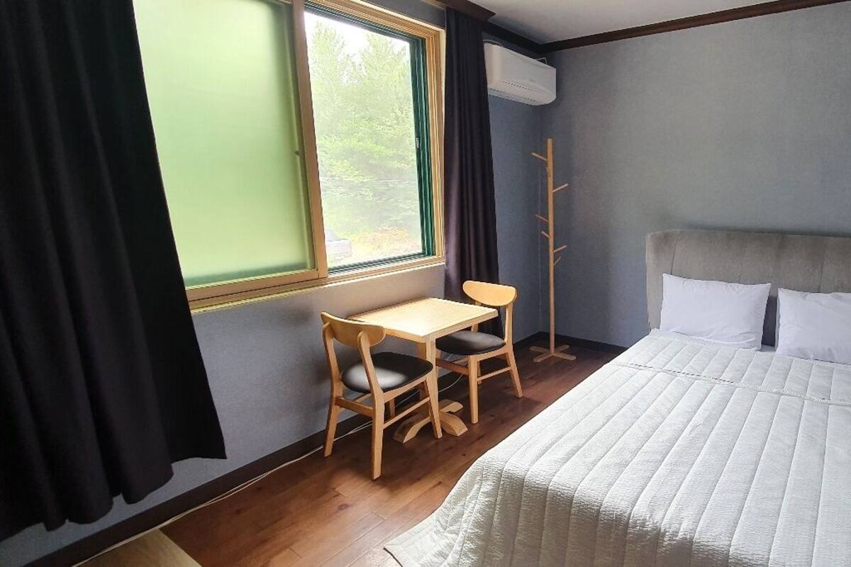 Un dormitorio con una cama, un escritorio y una silla.
