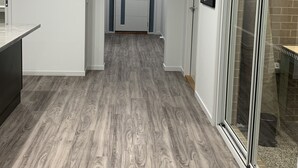 A hallway with a wooden floor, a clock on the wall, and a door at the end. - STONEHAVEN, perfect holiday accommodation for families. Close to GV Hospital (Shepparton)