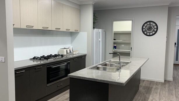 A modern kitchen with a central island, built-in oven, and stainless steel appliances. - STONEHAVEN, perfect holiday accommodation for families. Close to GV Hospital (Shepparton)