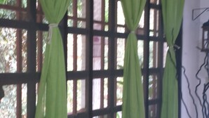 A window with green curtains and a grid pattern. - Manuela Antonio Comfort ocupado (Quepos)