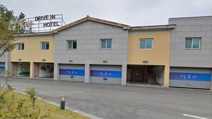 A hotel with multiple units, each with a garage door and a number displayed. - Jeju Ilua Hotel (Jeju City)