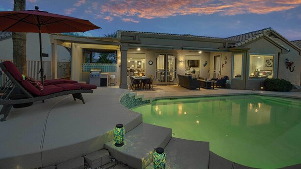 A poolside area with a lounge chair, a covered patio, and a pool. - Pool & Golf Cart: Sun City Grand Home! (Surprise)