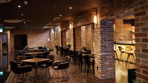 A restaurant with brick walls, wooden tables, and leather chairs. - Hotel The Star (Yeonggwang)