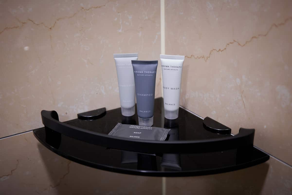A bathroom vanity with three toiletries: a body wash, a shampoo, and a soap.