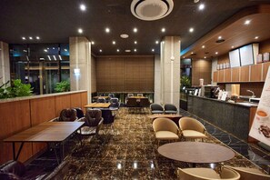 A modern restaurant with marble flooring, leather seating, and a counter with coffee machines. - Hotel The Star (Yeonggwang)