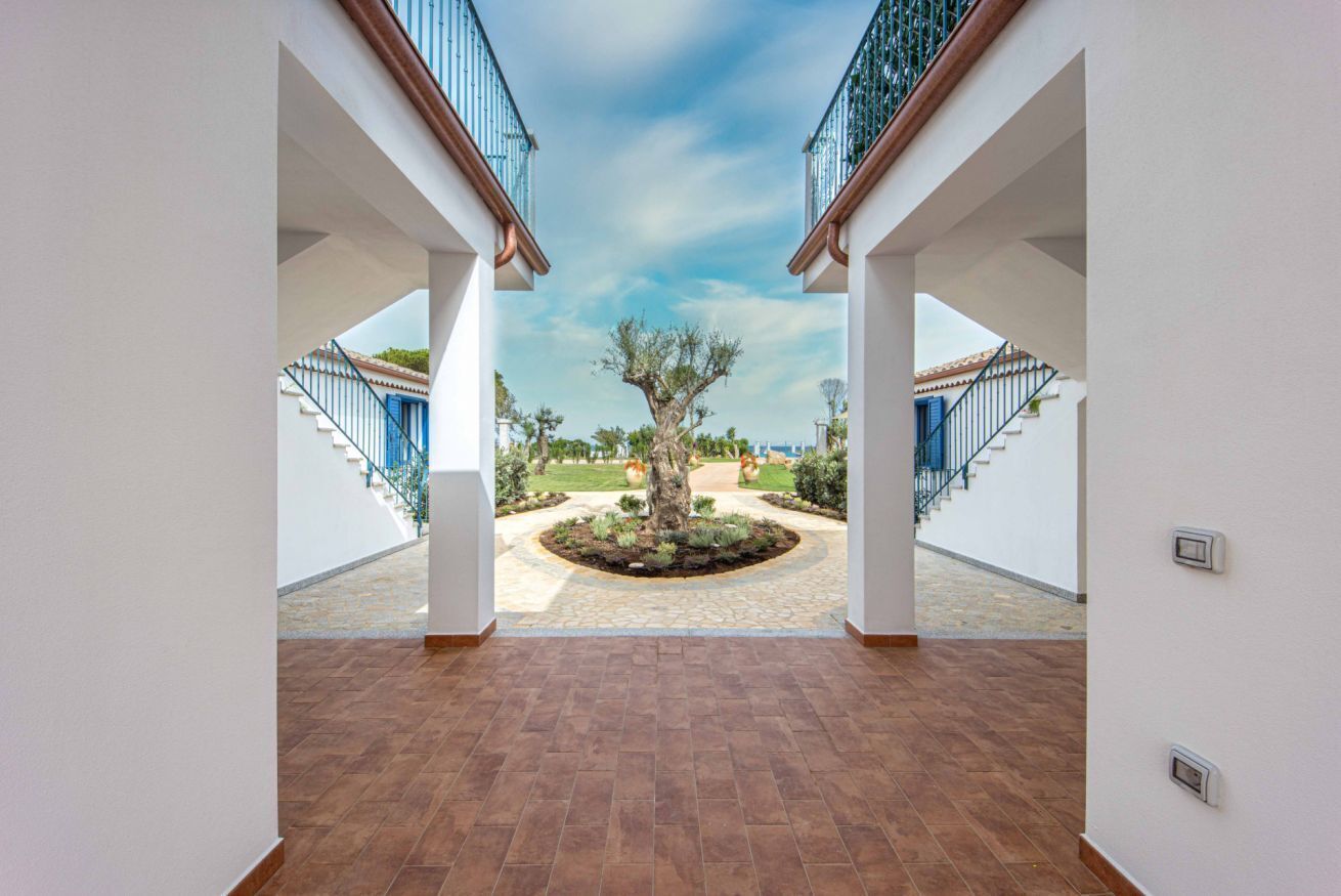 Un vaste espace intérieur donnant sur un jardin aménagé et comportant un escalier menant à l’extérieur.