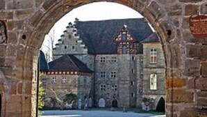 A historic stone building with a central courtyard, arched entrance, and traditional architecture.