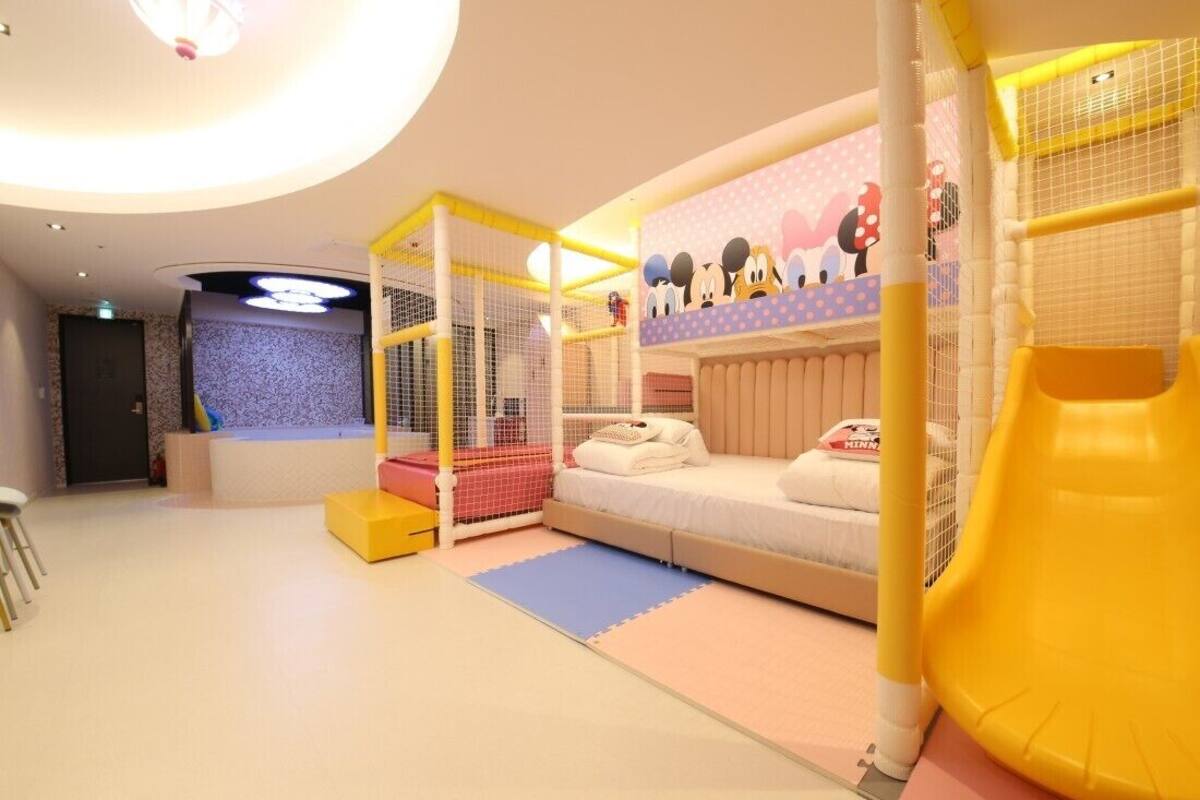 Zona de juegos infantiles con literas, parque infantil y tobogán.