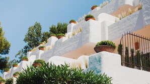 A white-washed building with terraced levels, each adorned with potted plants. - Ritual de Terra Javea Resort & Spa (Javea)