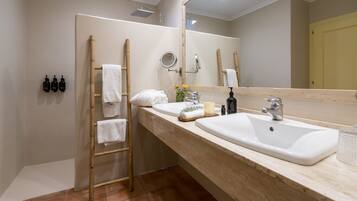 Un baño con un espejo grande, un lavabo y un perchero para toallas.
