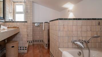A bathroom with a bathtub, a shower, and a sink.