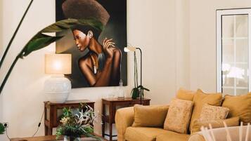 A living room with a sofa, coffee table, and a painting on the wall.
