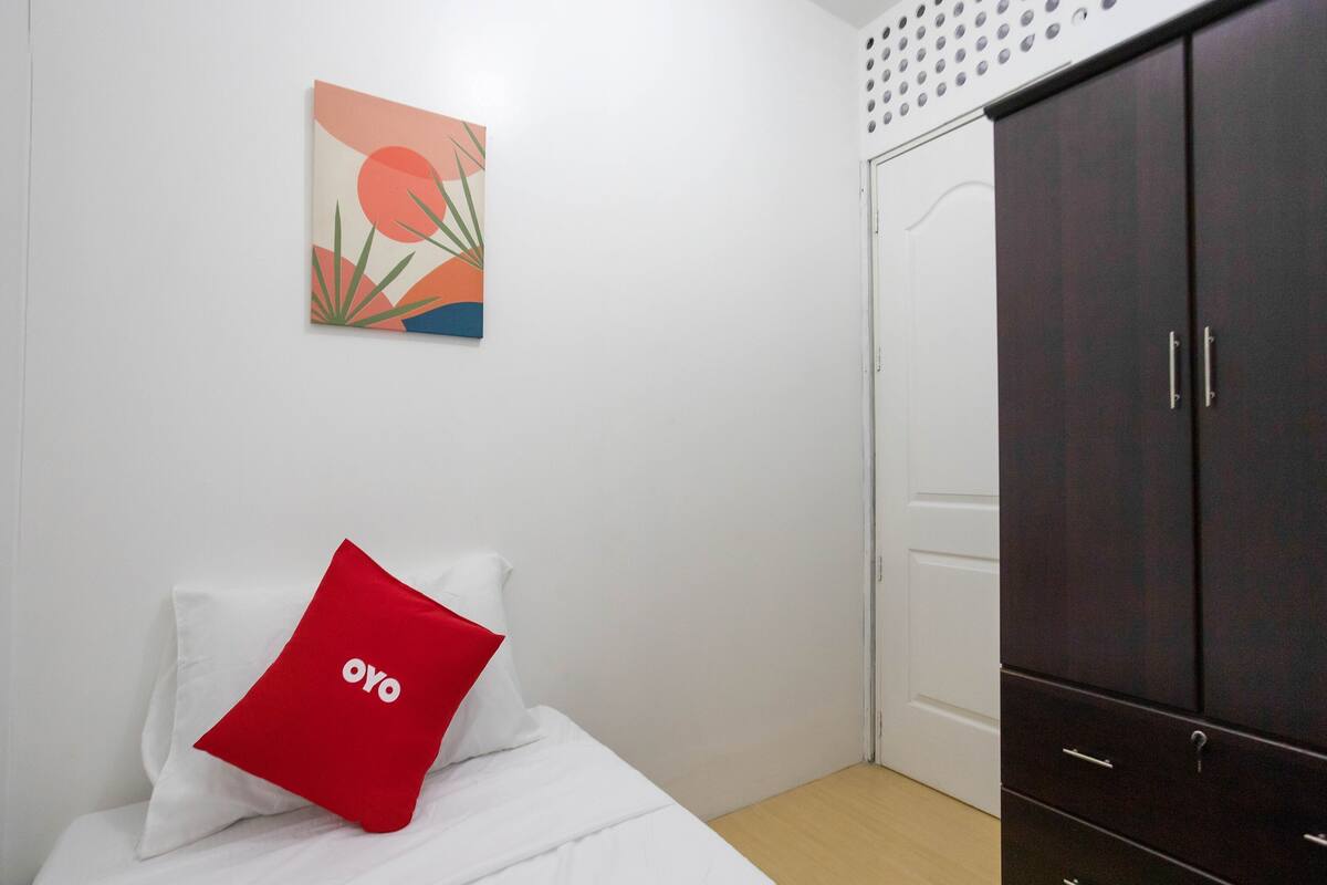 Une chambre à coucher comprenant un lit, une armoire, une porte et une œuvre d’art accrochée au mur.