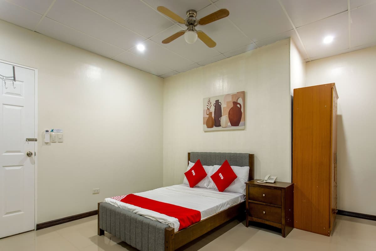 Une chambre bien rangée, avec un lit, une table de chevet et une armoire.