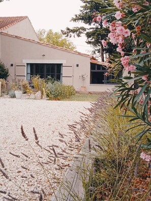 Un bâtiment moderne doté d’un toit plat, de grandes fenêtres et d ’une allée gravillonnée.