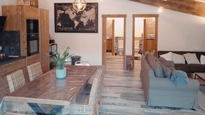 A spacious living area with a wooden ceiling, a dining table with chairs, a sofa, and a large world map on the wall. - 18th century gite mas in Provence with SPA (chateaurenard)