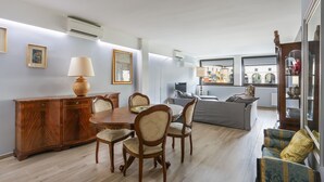 A dining area with a wooden table and chairs, a cabinet, and a sofa in the background. - Stunning view over Ponte Vecchio (Firenze)