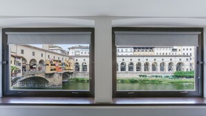 A room with two windows overlooking a historic bridge and a canal. - Stunning view over Ponte Vecchio (Firenze)