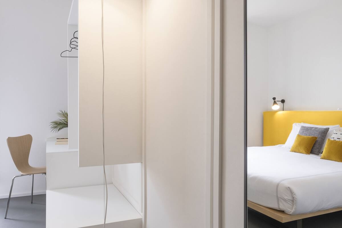 A modern bathroom with a white sink, a mirror, and a large floor lamp.