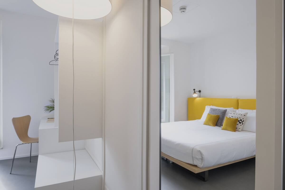 A modern bedroom with a bed, bedside table, and a chair.