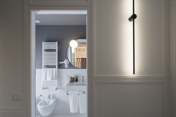 A modern bathroom with a bidet, a sink, and a mirror. - Camplus Hotel Roma Centro (Rome)