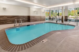 Una piscina interior con agua cristalina, paredes y piso de baldosas.