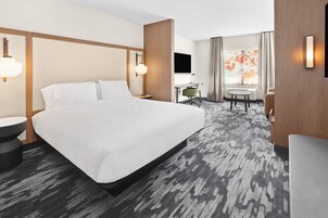 Una habitación de hotel con una cama grande, un escritorio, una silla y una mesita.