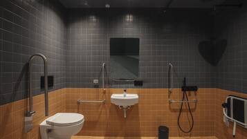 A modern bathroom with a white toilet, a sink, and a shower area.