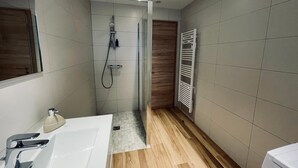 A modern bathroom with a shower, a sink, and a towel rack. - 3-room gîte with terrace (Wintzenheim)