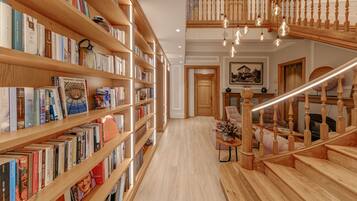 Una biblioteca amplia con estanterías de madera y una escalera central.