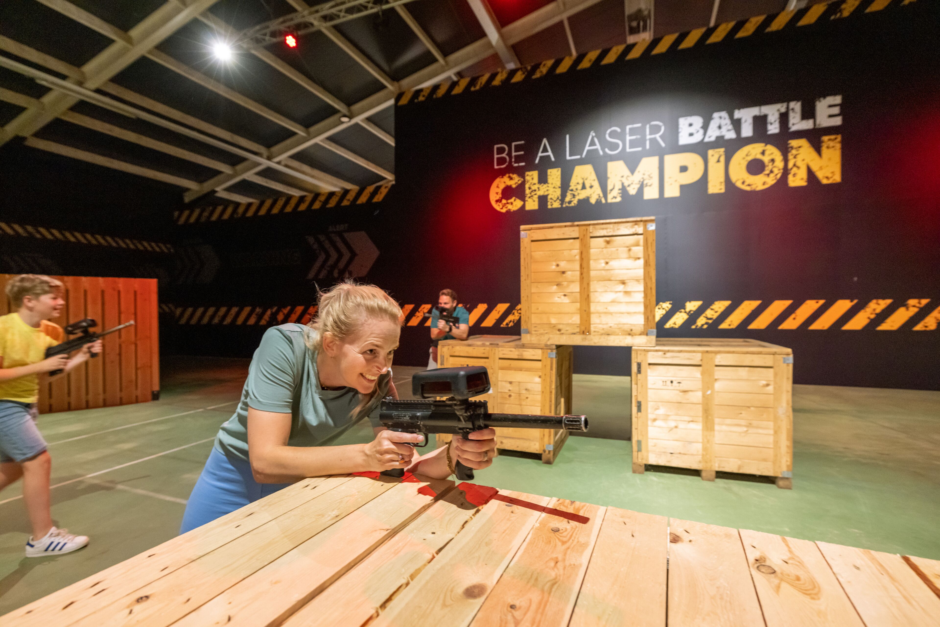 A laser tag arena with wooden crates and a motivational sign.