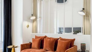 Una sala de estar moderna con un sofá marrón, una mesita redonda y una lámpara de pie alta.