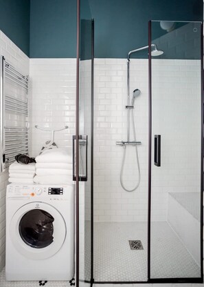 A modern bathroom with a glass-enclosed shower, a built-in washing machine, and a towel rack. - Cosy apartment in Sentier village - 1 bedroom - Steps from Montorgueil market - Montmartre by Habitat Parisien (Paris)