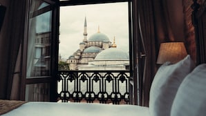 A hotel room with a large bed, a view of a mosque with a dome and minaret, and a balcony railing. - Mest Hotel Istanbul Sirkeci (Istanbul)
