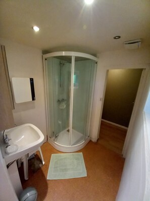 Een douche, een haardroger, handdoeken, toiletpapier