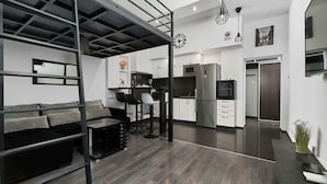 Un interior moderno con sofá, comedor, cocina y una escalera.