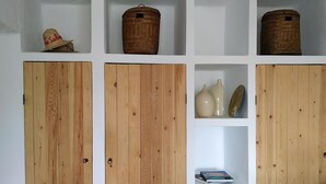 Une pièce avec des armoires et des étagères en bois contenant divers objets.