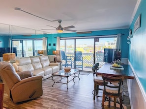 A living room with a sofa, chairs, a coffee table, and a dining area with a table and chairs. - Ocean Shores 301 (North Myrtle Beach)