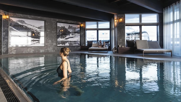 An indoor swimming pool with a person in the water, large windows, and a view of mountains. - Belambra Clubs Tignes - Val Claret (Tignes)