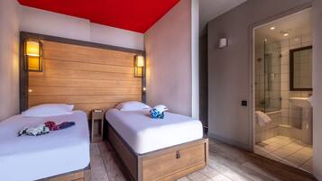 A hotel room with two beds, a wooden headboard, a red ceiling, and a glass shower enclosure.