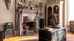 A vintage room with a fireplace, ornate wall decorations, and a bookshelf. - Immersion Experience Into a Fictional Magical World (Saint Joseph)