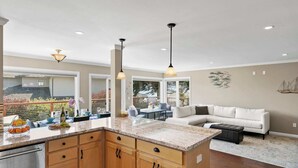 A spacious kitchen with a large island, wooden cabinets, and pendant lighting. - Shell's Treasure: Fully Updated Three bedroom home with Ocean Views (Pacific Grove)