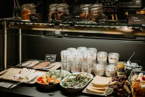 A buffet with various food items including fruits, vegetables, and dairy products.