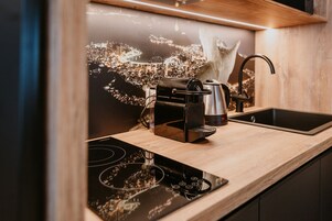 Una cucina moderna con una macchina del caffè, un bollitore e un lavello.