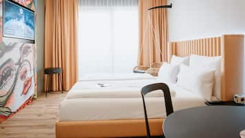 Een hotelkamer met een bed, een stoel, een tafel en een televisie aan de muur.